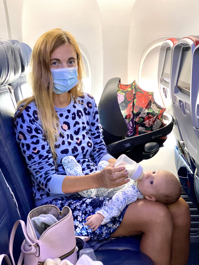 Mother feeding her baby on the plane, capturing the care needed when flying with a baby.